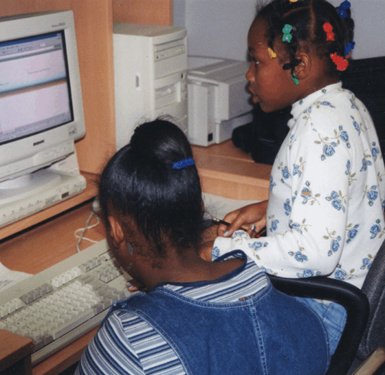 1990s photo of two girls using a desktop computer